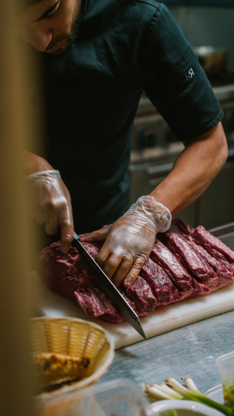 Le chef découpe la viande en cuisine