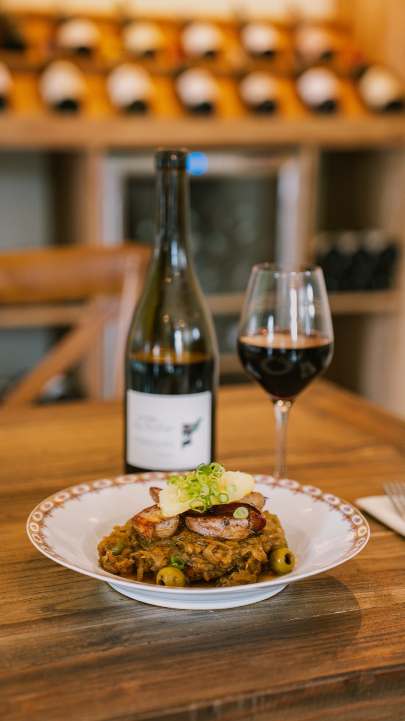 Plat mijoté aux olives et vin rouge devant la cave
